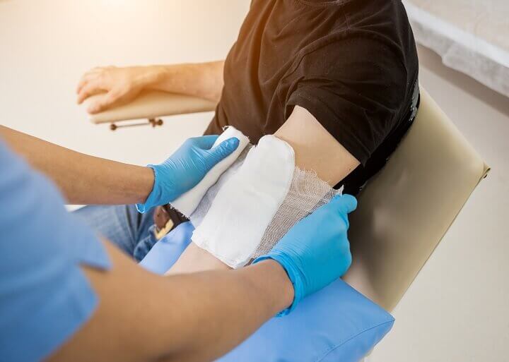 Nurse Dressing Wound On Arm