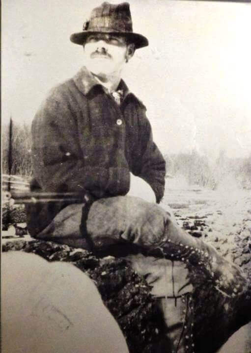 Old Photo of Man Sitting on Tree Trunk